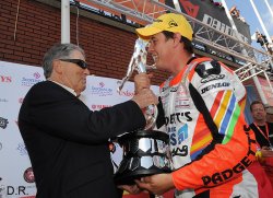 Geoff Duke remet le Trophée du Senior TT à Mc Guinness.